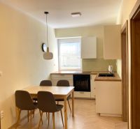 A kitchen with a dining table and a wooden decor floor in a 3-room apartment.