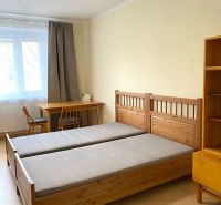 A bedroom with wooden beds, a table, and a floor with a wooden decor in a 3-room apartment.