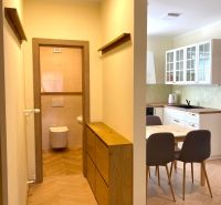 Interior of a 3-room apartment with a kitchen, dining area, and flooring with a wood decor.