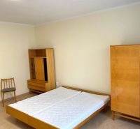 A bedroom with a bed, wardrobe, and wooden decor flooring in a 3-room apartment.