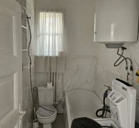 A narrow space with white doors and simple lighting in a family house.