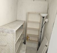 Storage space in a family house with shelves and a lamp.
