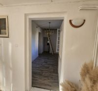 Living room with a television, wardrobe, window, and wooden decor flooring in a family house.