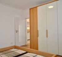 Wardrobe and bed frame in a 3-room apartment with a wooden decor floor.