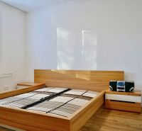 A bedroom with a bed and nightstands in a 3-room apartment, floor with wood decor.