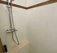 A shower corner with a handheld shower and tiling in a 3-room apartment.