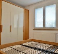 Bedroom with a bed without a mattress, built-in wardrobe and window, 3-room apartment.
