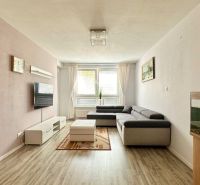 Living room in a 3-room apartment with a corner sofa and a wooden decor floor.