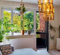 Seating with plants, a balcony, and knitted decorations in a 2-room apartment.