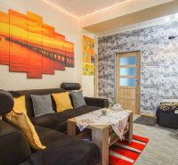 Living room in a two-room apartment with a comfortable sofa and colorful decorations.
