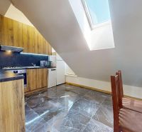 A kitchen in a 4-room apartment with a wooden decor and a bright skylight in the attic.