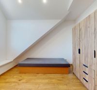 Bedroom in a 4-room apartment with wood-patterned flooring and storage space.