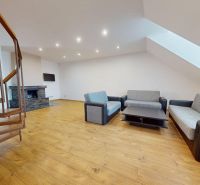 A staircase in the living room with a sofa set and a fireplace in a 4-room apartment.