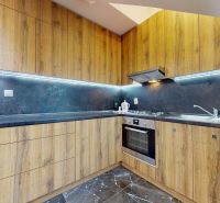 A kitchen with wood-decor cabinets and appliances in a 4-room apartment.