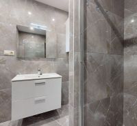 Bathroom in a 4-room apartment with tiles and a shower, elegant white cabinet.