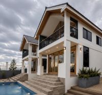 A family house in Pwani Mchangani with a pool, staircase, and wooden details.
