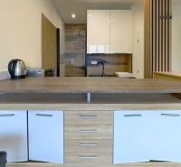 A kitchen in a holiday apartment with a wooden decor floor and a wooden table.