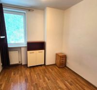 A room with a wooden decor floor in a studio apartment with light furniture.