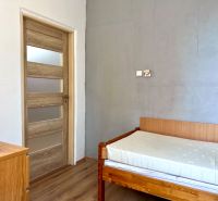 A room in a 2-room apartment with a bed and a floor with a wooden decor.