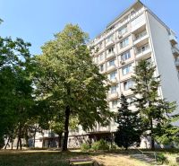 Apartment building on Piešťanská Street in Bratislava - Nové Mesto surrounded by greenery and a bench.
