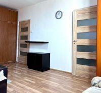 Living room in a two-room apartment with a wooden decor floor and furniture.