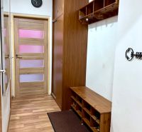 Entrance hallway with wood-patterned flooring, coat hooks, and a wardrobe in a 2-room apartment.