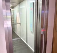 Elevator with a shiny floor in a 2-room apartment, white walls, illuminated ceiling.
