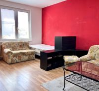Living room in a 2-room apartment with armchairs, a table, and a wooden decor floor.