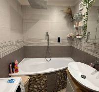 A bathroom with a bathtub and decorative tiles in a 4-room apartment.