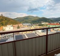 View from the balcony of a 4-room apartment in Nová Baňa to the mountains and buildings.