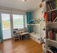 Children's room with a bed and shelves in a 4-room apartment, floor with wooden decor.