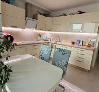 A kitchen in a 4-room apartment with white cabinets and a dining table.