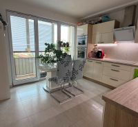 A kitchen in a 4-room apartment with a dining table and access to the balcony.