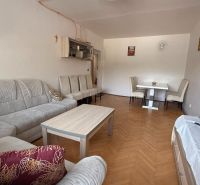 A living room in a 4-room apartment with a comfortable sofa set and a wooden decor floor.
