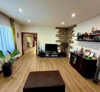 Living room in a family house with a wooden decor floor and decorative walls.