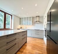 A bright kitchen with a cooktop, sink, and wooden decor flooring in a 3-room apartment.