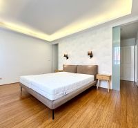 A bedroom in a 3-room apartment with a bed and a wooden decor floor.