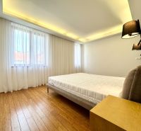 A bedroom in a three-room apartment with curtains and a wooden decor floor.