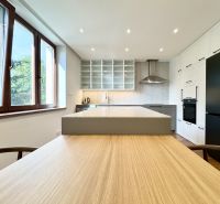 A kitchen in a 3-room apartment with an island and LED lighting, flooring with a wooden decor.