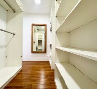 A wardrobe in a 3-room apartment with shelves and a wooden decor floor.