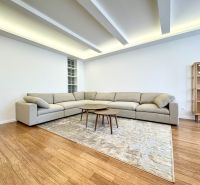 Living room in a 3-room apartment with a sofa, carpet on the floor with a wooden decor.