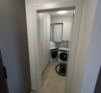 Laundry room with a white washing machine and dryer in a 3-room apartment.