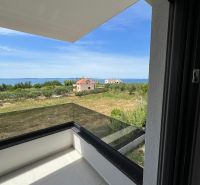 A balcony with a view of greenery and the sea in a 3-room apartment in Privlaka.