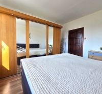 Bedroom in a 3-room apartment with a large wardrobe and a floor with a wooden decor.