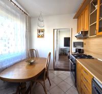 A kitchen in a 3-room apartment with a dining table, tiles, and wooden decor.
