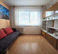 Living room with a sofa, cabinets, and wood-patterned flooring in a 3-room apartment.