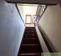 A staircase with a wooden railing leading to the upper part of the commercial premises.