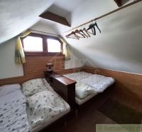 Attic room with two beds and a wooden decor floor in commercial premises.