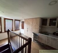 A kitchen with a wood-patterned floor and stairs in commercial premises.