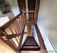 Interior with a wooden staircase next to the kitchen counter and a floor with a wooden decor.